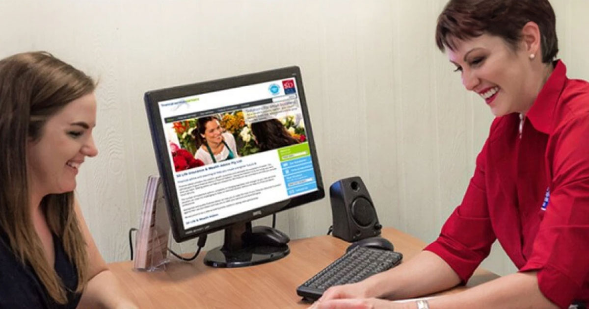 A photo of two person sitting in a table with an open desktop having a conversation about Lending Advice QLD.